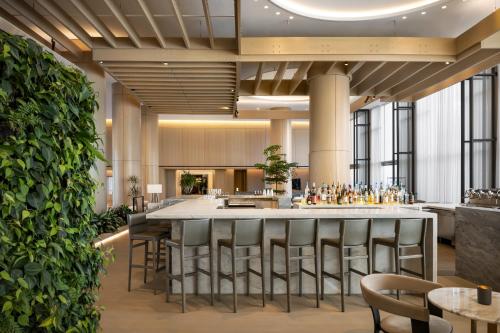 a large lobby with a bar with stools at Fairmont Century Plaza Los Angeles at Beverly Hills in Los Angeles