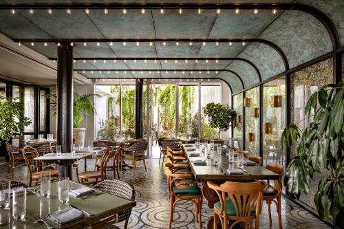a restaurant with tables and chairs and windows at Fairmont Century Plaza Los Angeles at Beverly Hills in Los Angeles