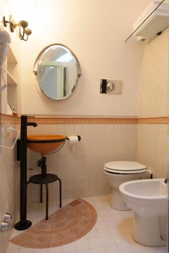a bathroom with a sink and a toilet and a mirror at La Dolce Vista - B&B di Charme in Manfredonia