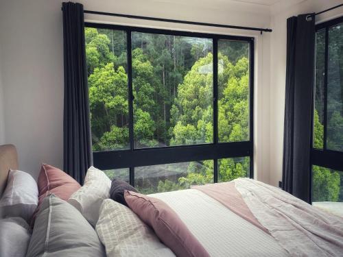 Currumbin ValleyPvc的一间带床和大窗户的卧室