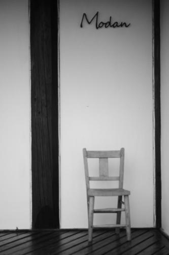 海の近くの宿 アトリエ モダン في ساكايميناتو: كرسي جالس على شرفة المنزل