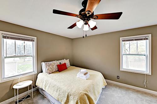 a bedroom with a ceiling fan and two windows at Acorn House in Fletcher