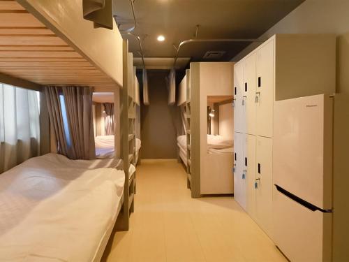 a room with two bunk beds and a hallway at Iwatoyama Hostel in Kyoto