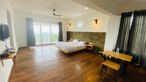 a bedroom with a bed and a large window at Hill Monk - Whispering Mist in Vagamon
