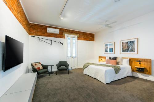 um quarto com uma cama e uma televisão de ecrã plano em The Royal Daylesford Hotel em Daylesford