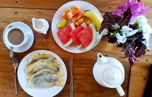 una mesa con dos platos de comida y una taza de café en Bara Beach Bungalows, en Bira