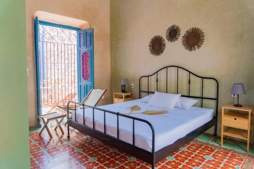- une chambre avec un grand lit et une grande fenêtre dans l'établissement Casa Nicté, hospédate en una casa del siglo XVIII, à Campeche