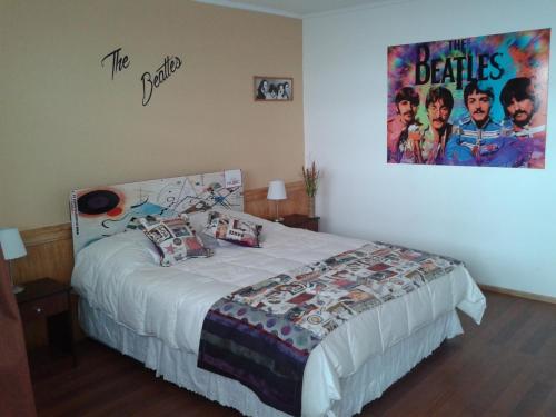 a bedroom with a bed with a movie poster on the wall at Hotel Ecomusic in Valparaíso