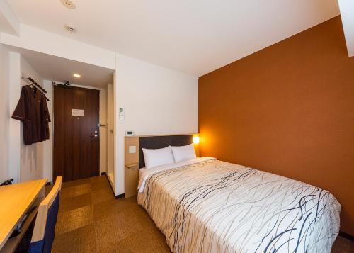 une chambre d'hôtel avec un lit et un bureau dans l'établissement Manten no Yu Michi no Yado, à Nonoichi