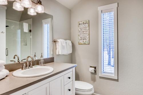 a bathroom with a sink and a toilet and a mirror at Forest Hideaway in Sunriver