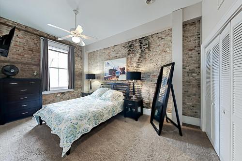 a bedroom with a bed and a brick wall at Market Street Loft in Wilmington