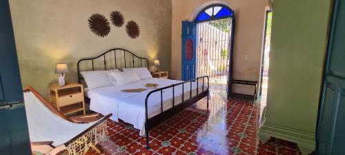a bedroom with a bed and a window and a door at Casa Nicté, hospédate en una casa del siglo XVIII in Campeche