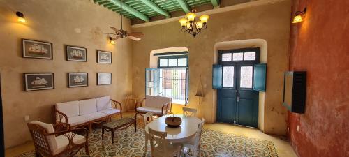 - un salon avec une table, des chaises et une porte dans l'établissement Casa Nicté, hospédate en una casa del siglo XVIII, à Campeche