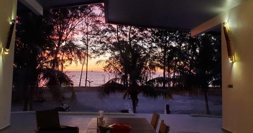 a view of the ocean from a room with a window at Eagle Bay Retreat Borneo Beach Villas Beach Front in Kumbatang