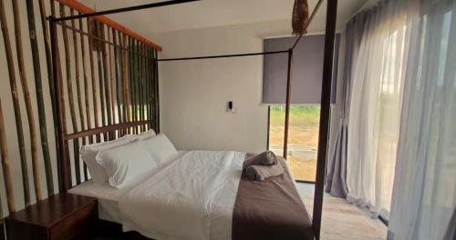 1 dormitorio con cama con dosel y ventana en Eagle Bay Retreat Borneo Beach Villas Beach Front, en Kumbatang