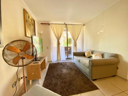 sala de estar con sofá y ventilador en Apartamentos Alma Surire en Arica