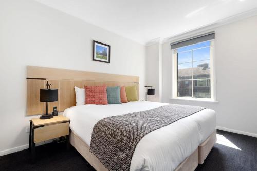 A bed or beds in a room at South Yarra Central Apartment Hotel