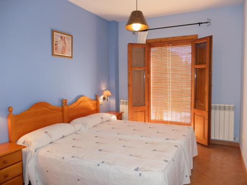 1 dormitorio con 1 cama grande y paredes azules en Apartamentos Cañones de Guara y Formiga, en Panzano