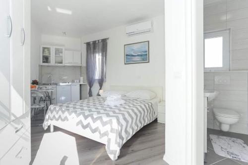 Cette chambre blanche dispose d'un lit et d'une cuisine. dans l'établissement Villa Ivica - with pool, à Vinišće