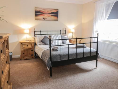 a bedroom with a bed and a dresser and a window at The Antlers in Coldstream