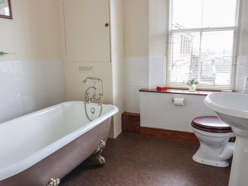 a bathroom with a tub and a toilet and a sink at The Antlers in Coldstream