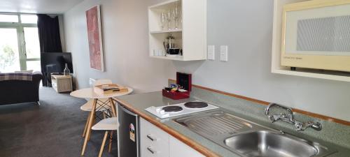 een keuken met een wastafel en een aanrecht bij The Wharf Seaview Apartments by AVI in Akaroa