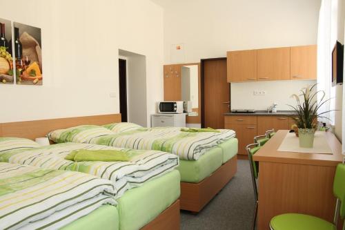 a row of beds in a room with a kitchen at Penzion Bobule in Staré Město