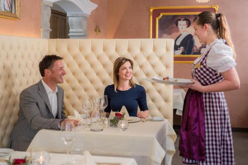a woman holding a plate of food in a restaurant at Wellnesshotel Cervosa in Serfaus
