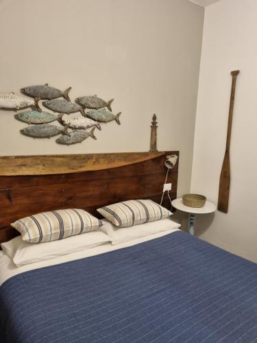 a bedroom with a bed with a wooden head board at VILLA VILLACOLLE in Procchio