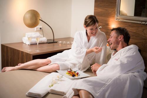 a woman sitting next to a man in a hotel room at Wellnesshotel Cervosa in Serfaus
