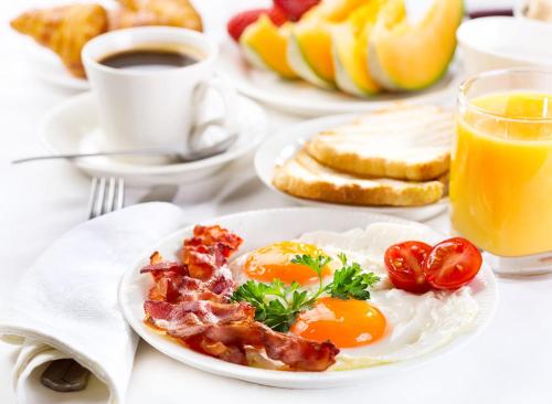 a plate of eggs and bacon and toast on a table at Hotel Alexandra in Hong Kong