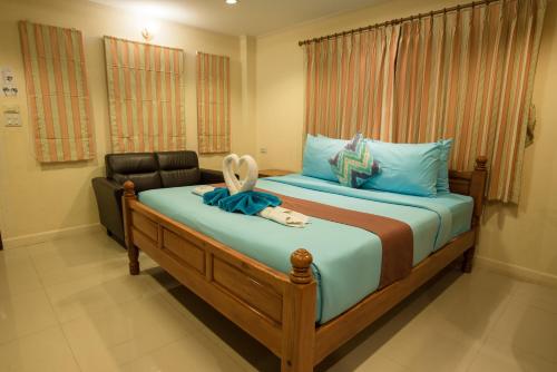 a bedroom with a bed with blue sheets and a chair at Lareena Resort Koh Larn Pattaya in Ko Larn