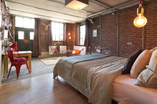 a bedroom with a bed and a brick wall at B&B Bij Tante Toos in Lemiers