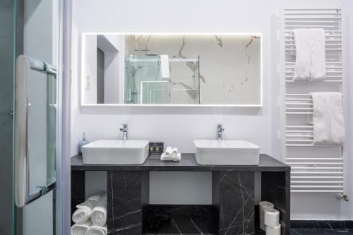 a bathroom with two sinks and a mirror at JOYME Hotel in Sibiu