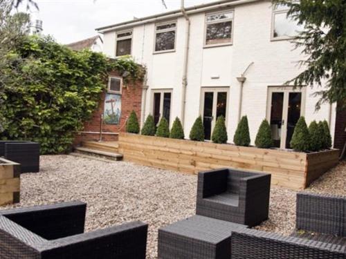 a yard with black chairs in front of a house at The Blue Anchor in Feering