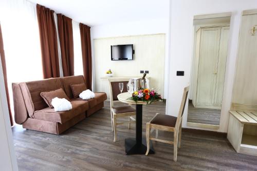 a living room with a couch and a table at Hotel Sole Relax & Panorama in Riva del Garda