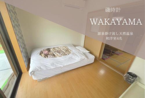 a small room with a bed in the corner at Hotel Isodokei in Shirahama