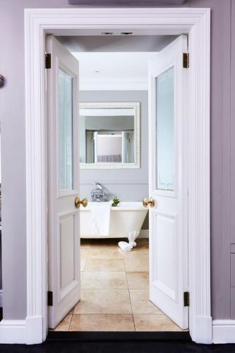 an open door leading to a bathroom with a tub at The Devon Valley Hotel in Stellenbosch