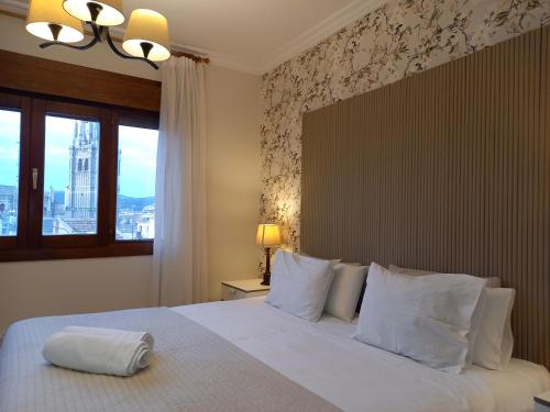 a bedroom with a bed with white pillows and a window at Martin Gamero Apartments in Toledo