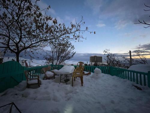 a table and chairs in the snow on a fence at Mandala in Mount מנדלה בחרמון סוויטה in Majdal Shams