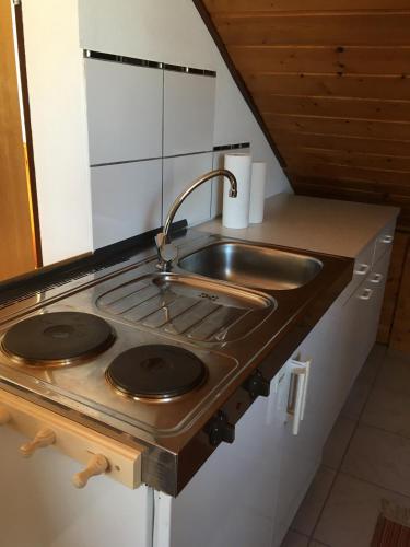 a kitchen with a stove and a sink at Sonnige Dachgeschoßwohnung in Niederkassel