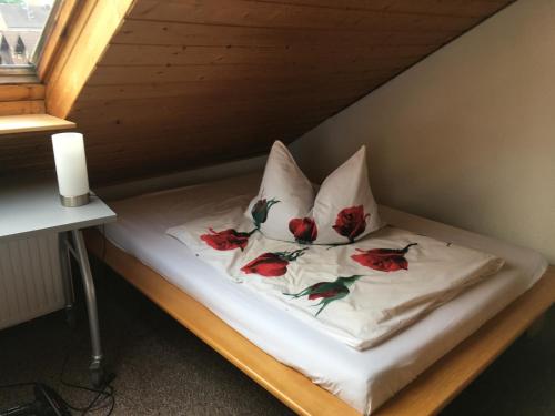 een bed met twee kussens met bloemen erop bij Sonnige Dachgeschoßwohnung in Niederkassel