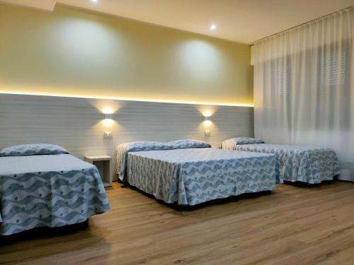 リミニにあるPark Hotelの青い掛け布団付きのベッド3台が備わる客室です。