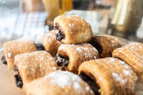uma pilha de donuts com açúcar de confeiteiro em um prato em Petit Palace Alcalá em Madrid