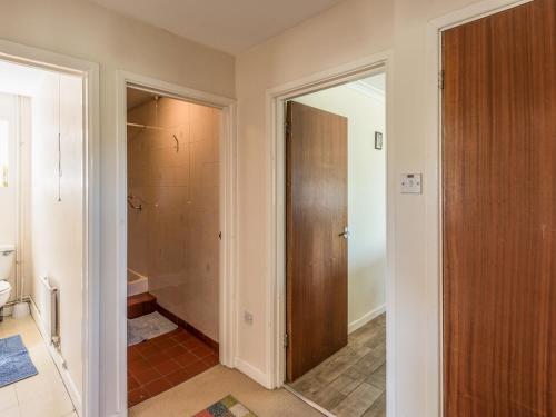 a bathroom with a toilet and a door to a shower at The Bungalow in Cleobury Mortimer