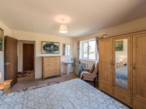 a bedroom with a bed and a desk and a sink at The Bungalow in Cleobury Mortimer