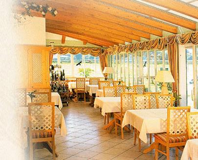 ein Restaurant mit weißen Tischen, Stühlen und Fenstern in der Unterkunft Eichenhof in Waging am See