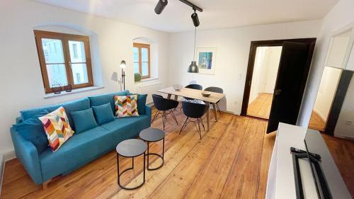 ein Wohnzimmer mit einem blauen Sofa und einem Tisch in der Unterkunft Wassergasse 11 in Regensburg