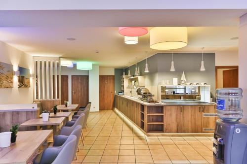 a restaurant with tables and chairs and a kitchen at City-Hotel-Wolgast in Wolgast