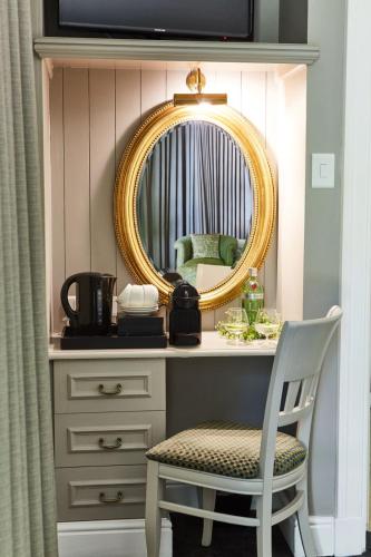 a dressing table with a chair and a mirror at The Devon Valley Hotel in Stellenbosch